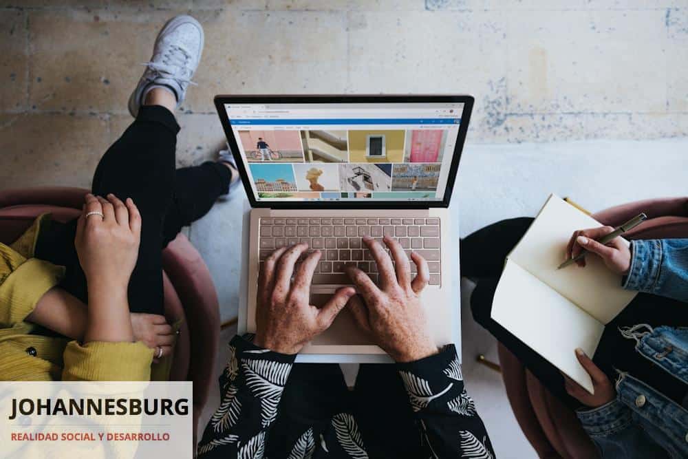 person using microsoft surface laptop on lap with two other people