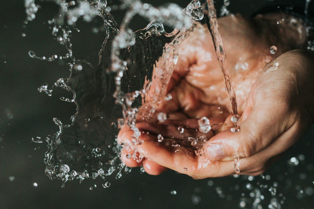 Manos recogiendo agua limpia, símbolo del ODS 6 de los objetivos de desarrollo sostenible